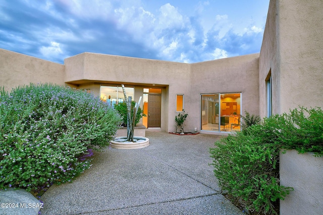 view of exterior entry featuring a patio