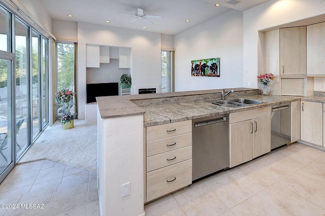 kitchen featuring light stone countertops, dishwasher, light carpet, sink, and kitchen peninsula