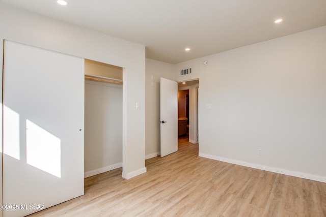 unfurnished bedroom featuring light wood-type flooring and a closet