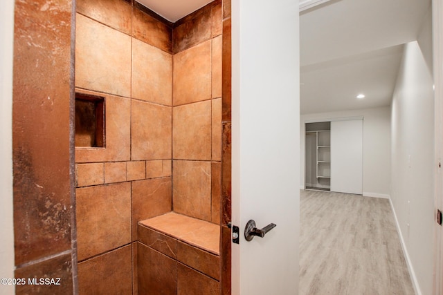 bathroom featuring wood-type flooring and walk in shower