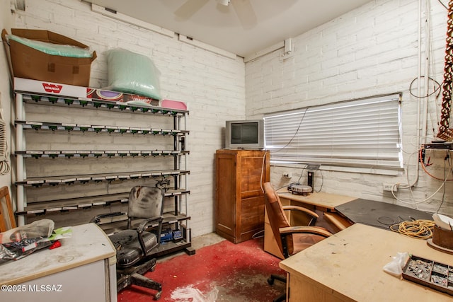 office space with ceiling fan, brick wall, and concrete flooring