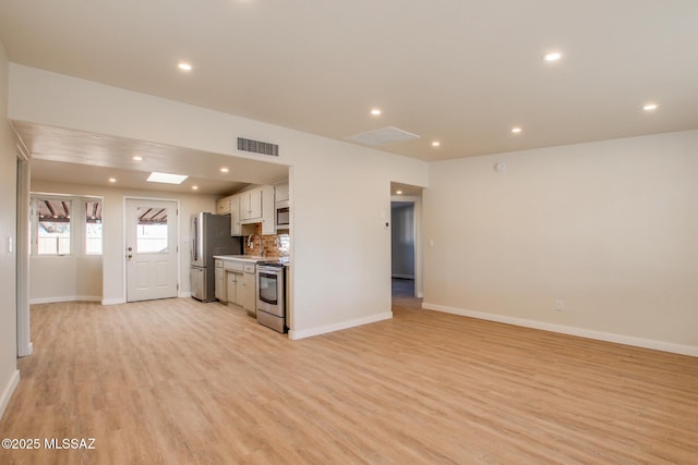 kitchen featuring white cabinetry, appliances with stainless steel finishes, light hardwood / wood-style flooring, and tasteful backsplash