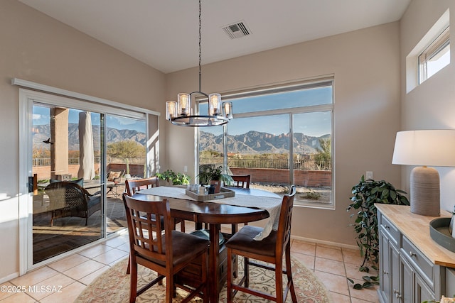 dining space with a mountain view, plenty of natural light, and light tile patterned floors