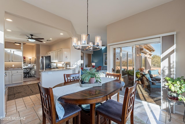 tiled dining room with ceiling fan with notable chandelier