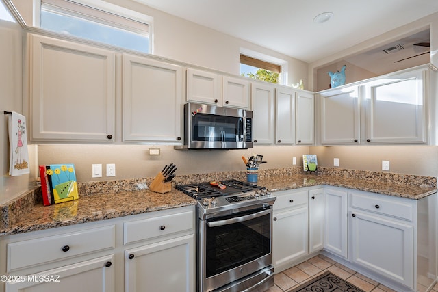 kitchen featuring stainless steel appliances, stone countertops, and white cabinets