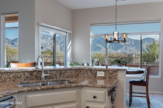 kitchen featuring white cabinetry, a mountain view, and sink