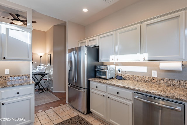 kitchen with light tile patterned floors, ceiling fan, stainless steel appliances, light stone countertops, and white cabinets