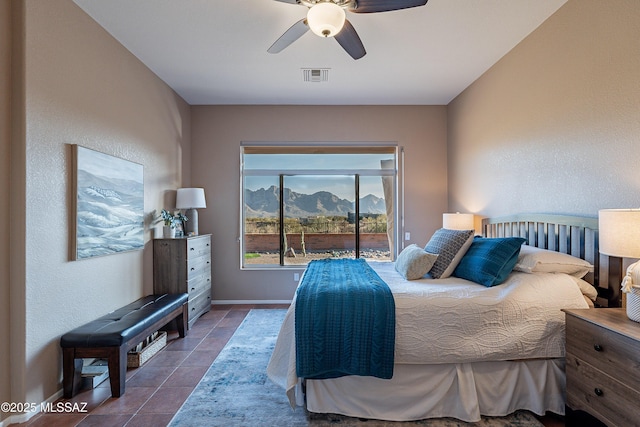 bedroom with tile patterned flooring, a mountain view, and ceiling fan