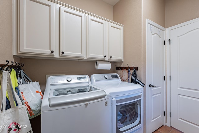 laundry area with independent washer and dryer and cabinets