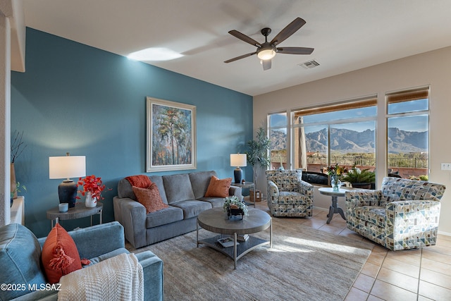 living room featuring ceiling fan, a mountain view, and light tile patterned floors