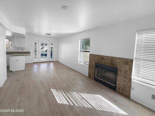 unfurnished living room with a fireplace and light hardwood / wood-style floors