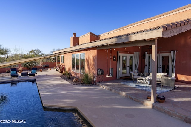 back of property featuring french doors, an outdoor hangout area, and a patio