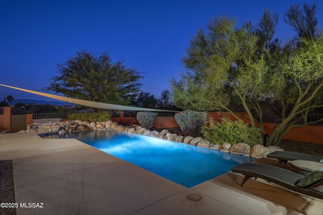 pool at dusk featuring a patio area