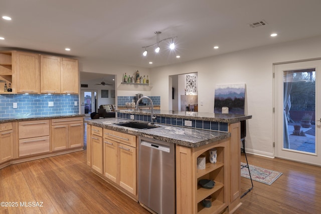 kitchen featuring a kitchen island, sink, a kitchen breakfast bar, stainless steel dishwasher, and light brown cabinets