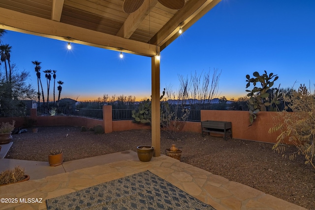 patio terrace at dusk featuring ceiling fan