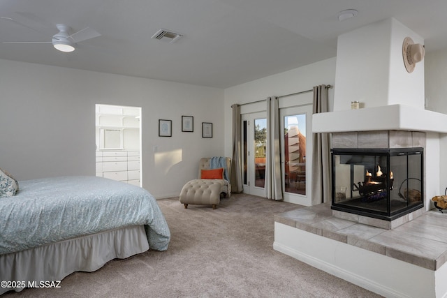 bedroom with a tiled fireplace and carpet