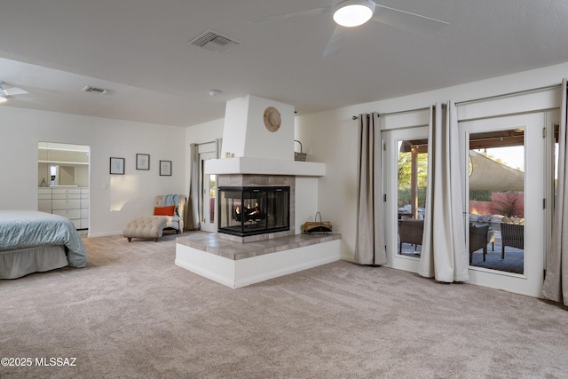 interior space with ceiling fan, a tile fireplace, and carpet