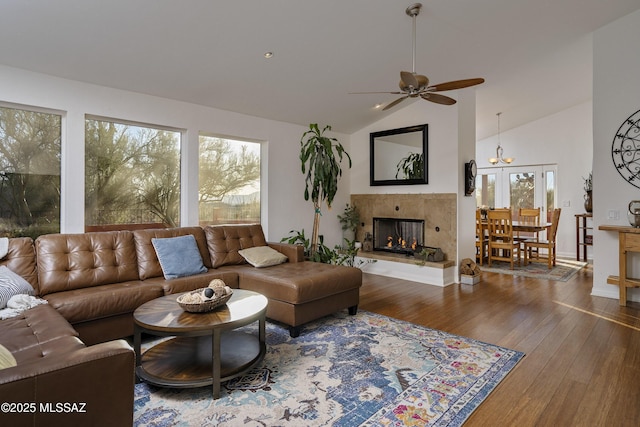 living room featuring wood-type flooring, high vaulted ceiling, ceiling fan, and a multi sided fireplace