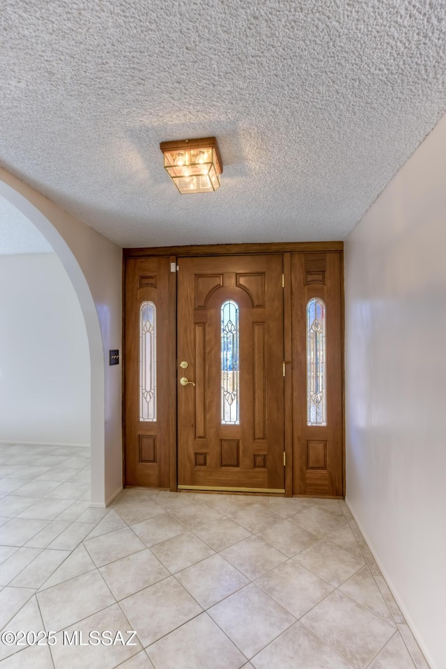 tiled foyer entrance with a textured ceiling