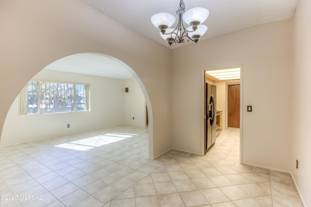 unfurnished room with light tile patterned floors and a chandelier