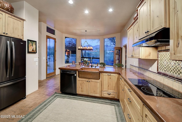 kitchen with pendant lighting, tasteful backsplash, black appliances, kitchen peninsula, and light brown cabinets