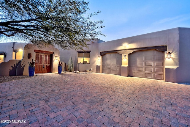 pueblo revival-style home featuring a garage