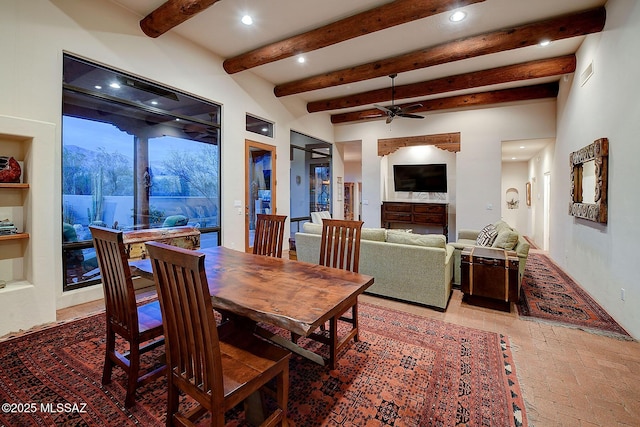 dining area featuring beamed ceiling, ceiling fan, and a mountain view