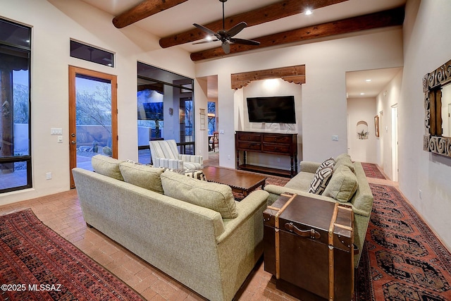 living room featuring beamed ceiling and ceiling fan