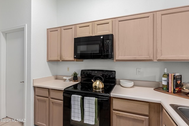 kitchen with black appliances and light brown cabinets