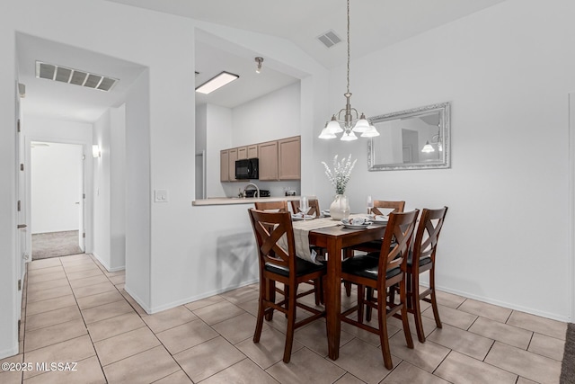 tiled dining room with vaulted ceiling and a notable chandelier