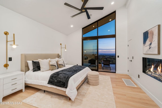 bedroom with access to exterior, high vaulted ceiling, ceiling fan, and light wood-type flooring