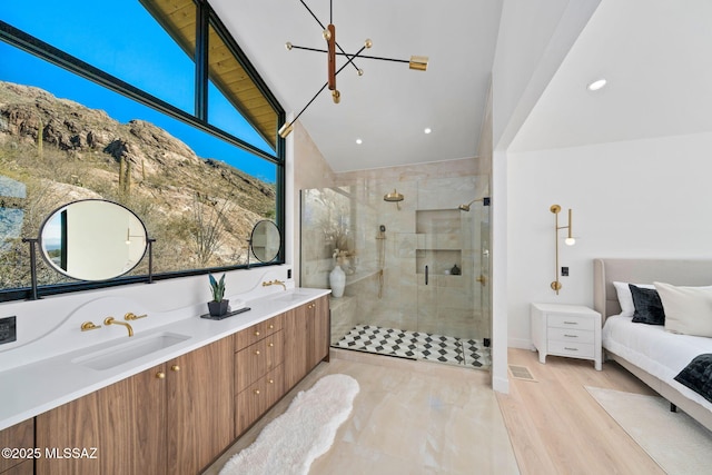 bathroom featuring vaulted ceiling, hardwood / wood-style floors, a shower with shower door, vanity, and an inviting chandelier