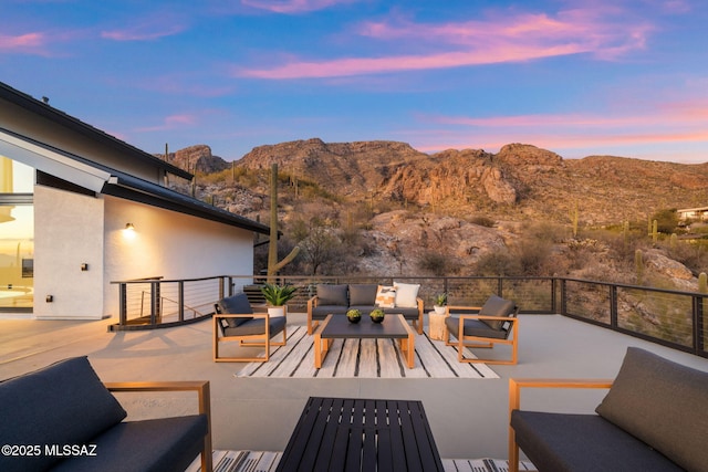 patio terrace at dusk featuring an outdoor living space and a mountain view