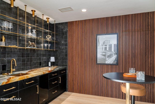 bar featuring wood-type flooring and sink