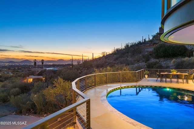 pool at dusk featuring a mountain view