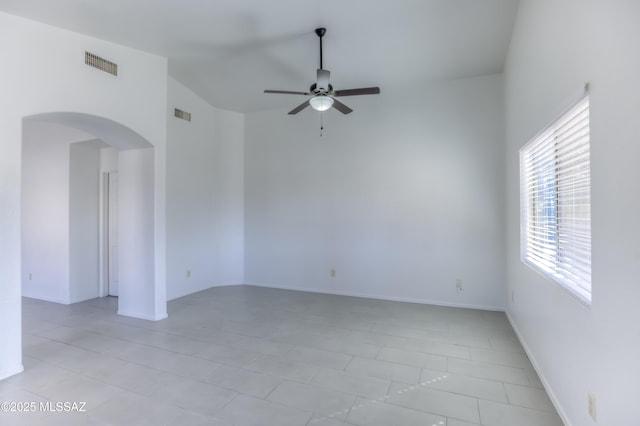 tiled spare room with vaulted ceiling and ceiling fan