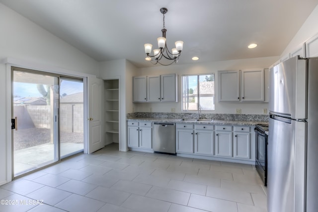 kitchen with vaulted ceiling, sink, decorative light fixtures, a chandelier, and stainless steel appliances