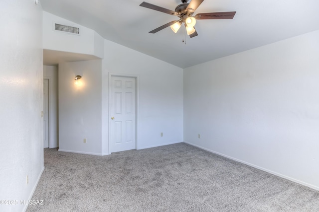 carpeted spare room featuring vaulted ceiling and ceiling fan