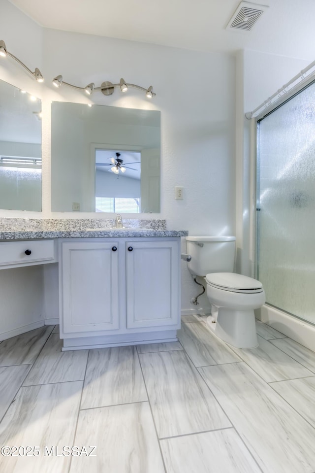 bathroom with an enclosed shower, vanity, and toilet