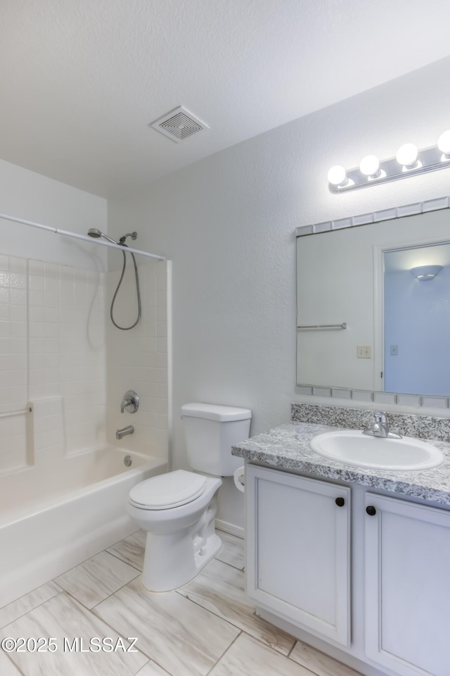 full bathroom featuring a textured ceiling, shower / bathing tub combination, vanity, and toilet