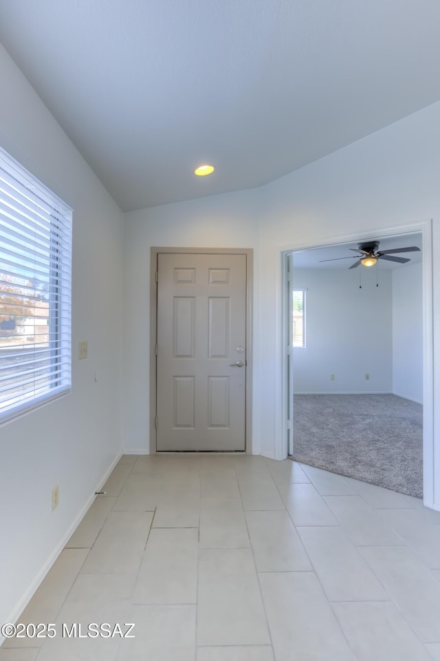 unfurnished room with vaulted ceiling, ceiling fan, and light colored carpet