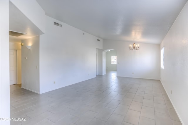 unfurnished room featuring a chandelier