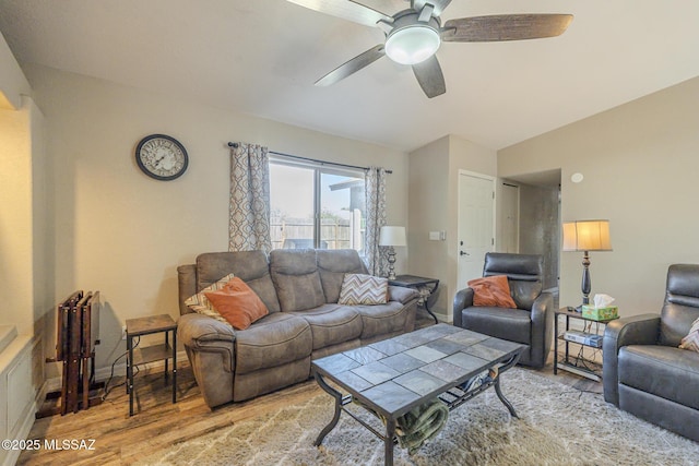 living area with light wood finished floors, ceiling fan, and baseboards