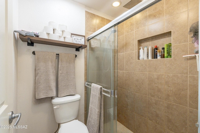 bathroom with a shower stall and toilet