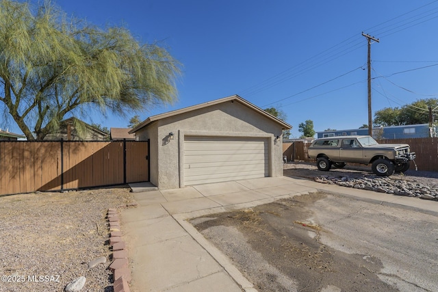 garage with driveway and fence