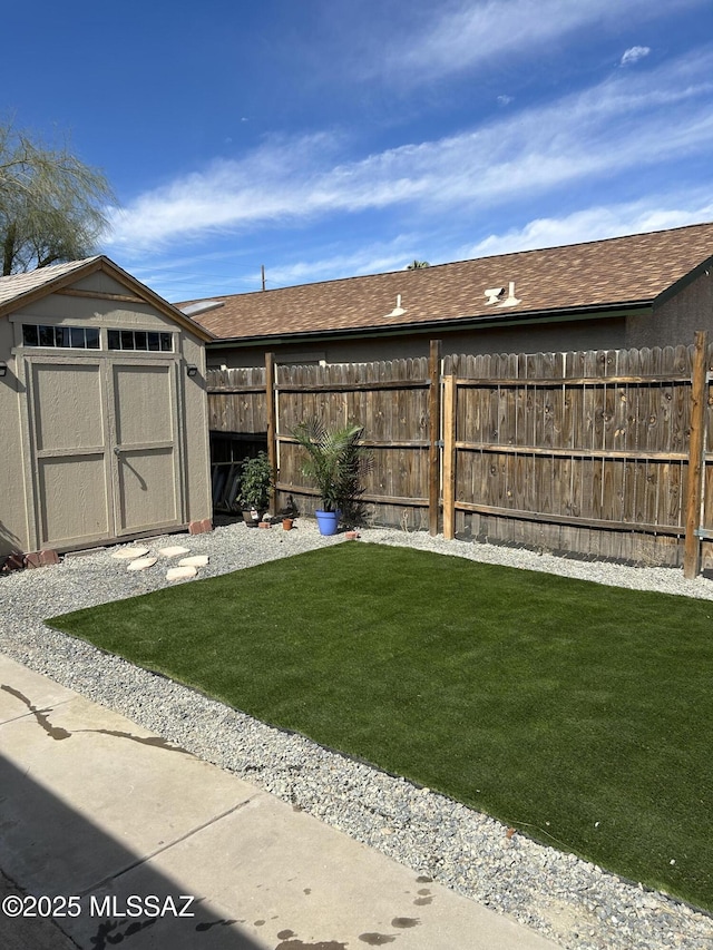 view of yard featuring a shed, an outdoor structure, and a fenced backyard