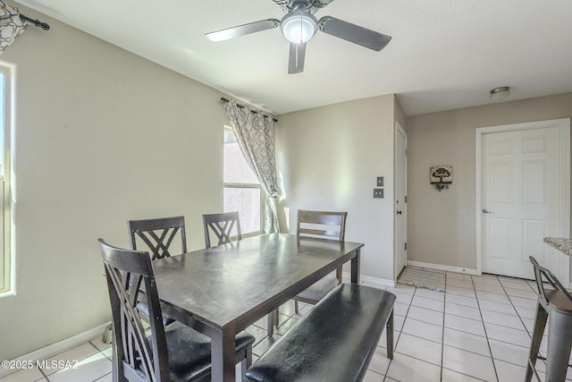 dining room featuring ceiling fan, baseboards, and light tile patterned floors