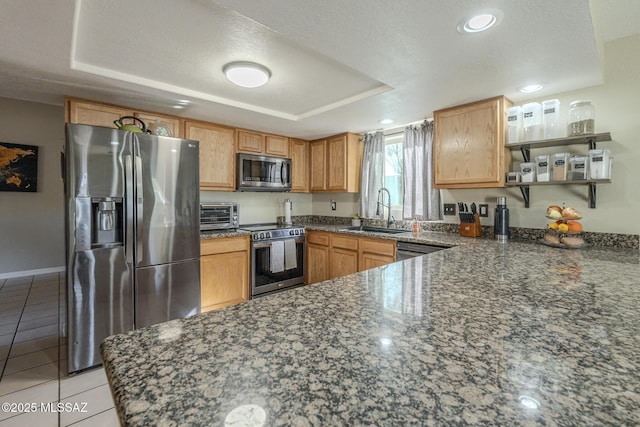kitchen featuring light tile patterned floors, appliances with stainless steel finishes, a tray ceiling, open shelves, and a sink