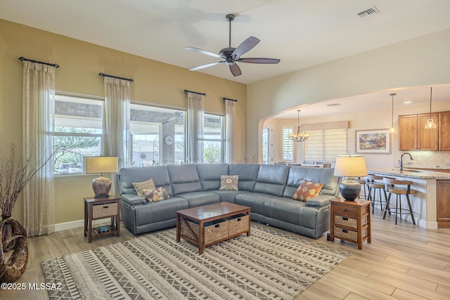 living room with light hardwood / wood-style flooring, sink, and a wealth of natural light