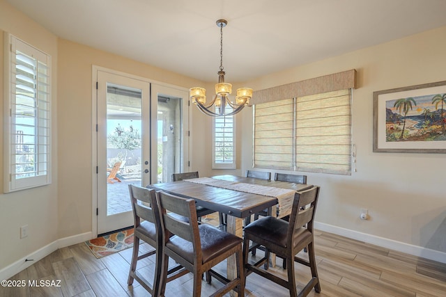 dining room featuring a chandelier, light hardwood / wood-style floors, and french doors